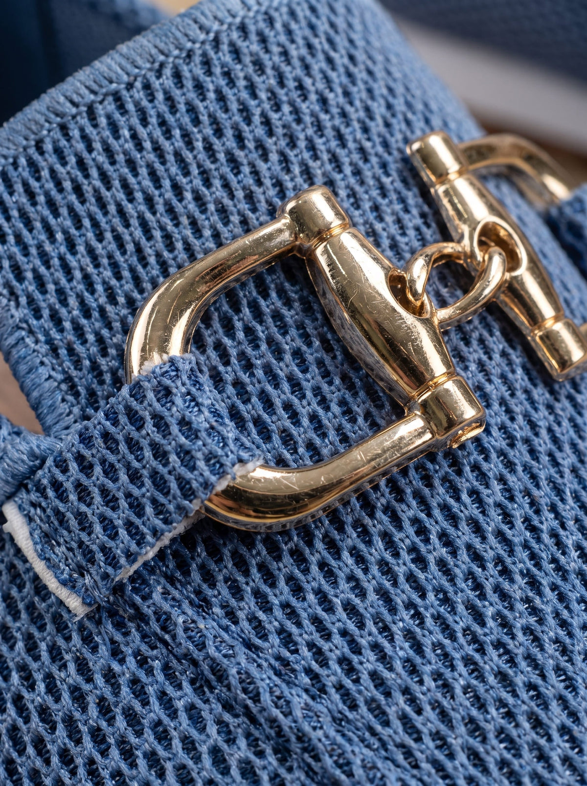 Close-up of navy mesh and gold-tone buckle