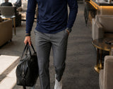 Navy Ronan polo in a modern travel lounge