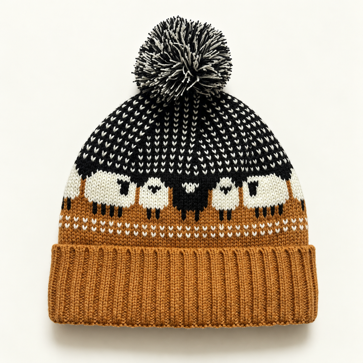 Black Camel sheep-pattern Fair Isle pom-pom beanie on a clean warm-white background